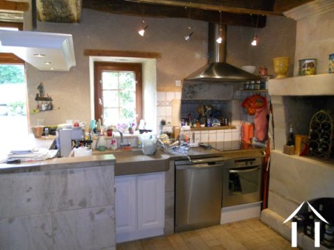 Vanuit de open keuken met een oud stenen aanrecht is er zicht op de zitkamer.