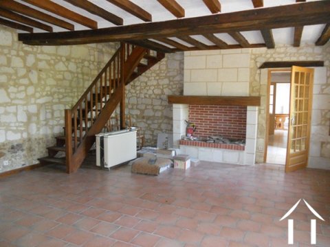 Dit is de originele zitkamer met open haard. Vanuit hier gaat de trap naar boven naar de twee tweepersoonsslaapkamers en grote moderne badkamer.