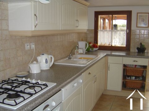 The modern fitted 'gallery' style kitchen with the veranda beyond.