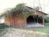 At the end of the driveway is a large timber outbuilding that includes a workshop and carport.