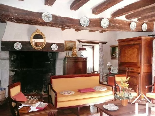  In de zitkamer is de leeftijd van het pand goed te zien. Vanaf hier is direct toegang naar de buitentrap, naar beneden naar het terras en naar het aflopende pad naar de rivier. 