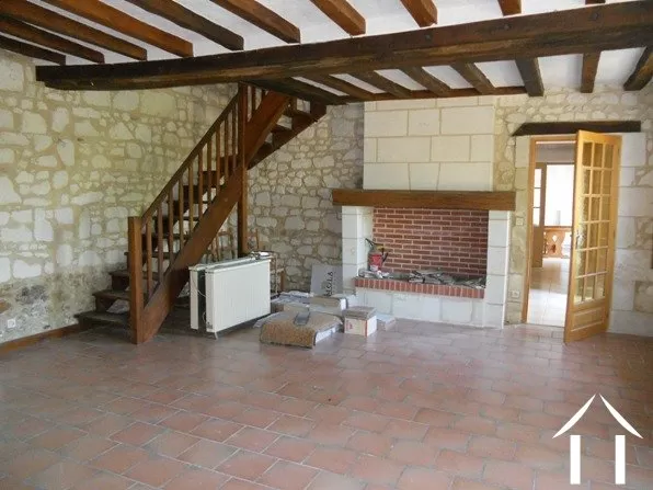 Dit is de originele zitkamer met open haard. Vanuit hier gaat de trap naar boven naar de twee tweepersoonsslaapkamers en grote moderne badkamer.