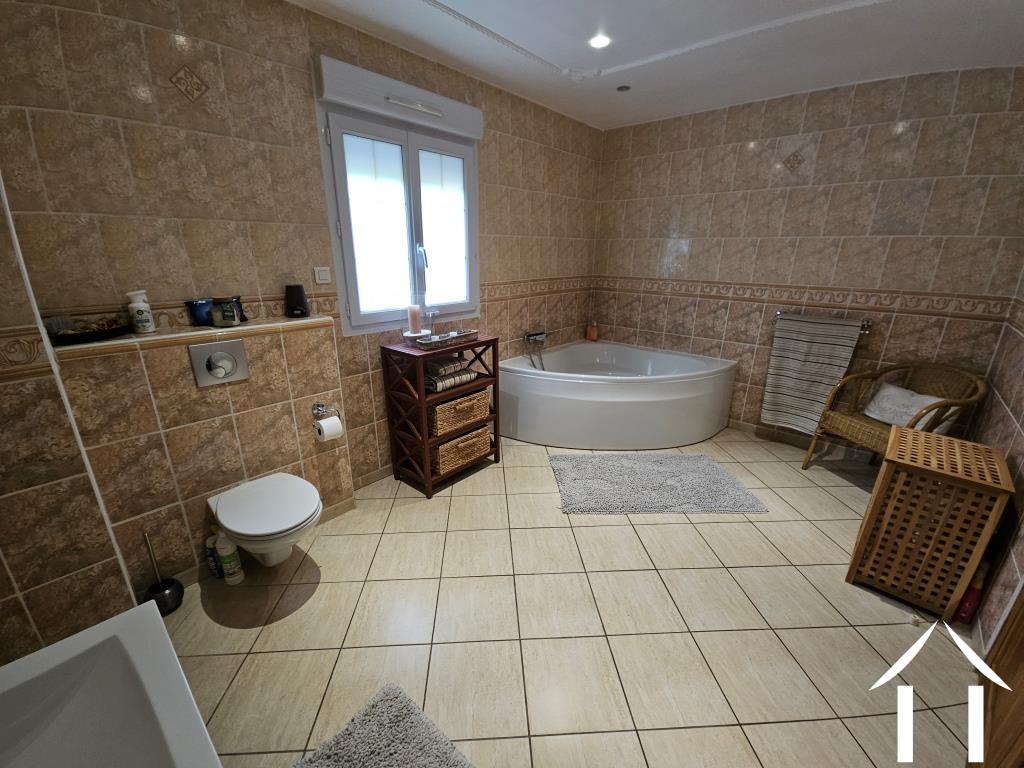 Badkamer met hoekbad, douche, wastafel en toilet