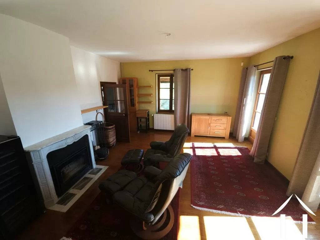 Woonkamer met open haard en toegang tot het balkon terras