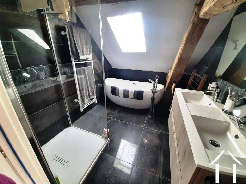 Badkamer met bad, douche en dubbele wastafels