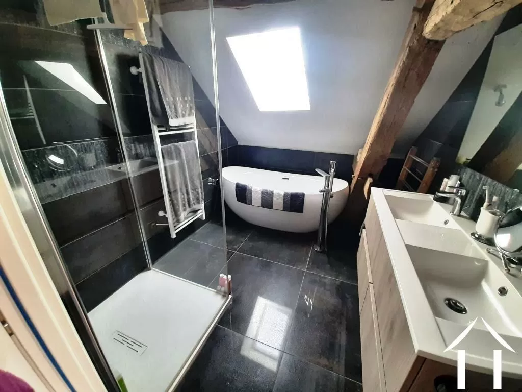 Badkamer met bad, douche en dubbele wastafels