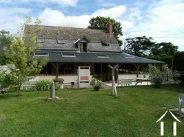 GROOT HUIS MET BIJGEBOUWEN EN GRASVELD MET PAARDENBOXEN
