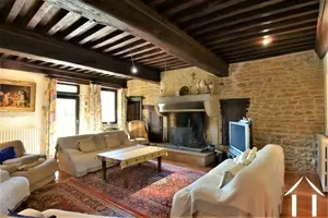 living room with beams and stone fireplace