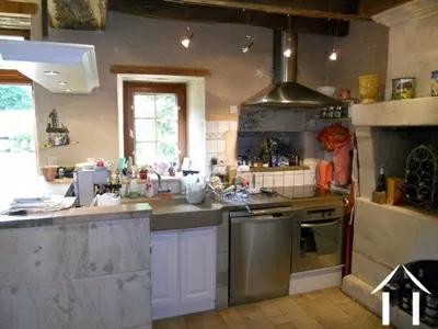 Vanuit de open keuken met een oud stenen aanrecht is er zicht op de zitkamer.