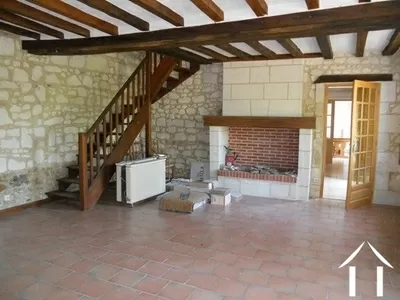 Dit is de originele zitkamer met open haard. Vanuit hier gaat de trap naar boven naar de twee tweepersoonsslaapkamers en grote moderne badkamer.