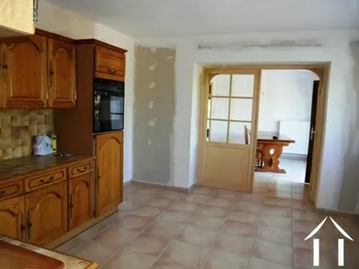 De keuken ligt letterlijk in het centrum van het huis, met grote openslaande deuren naar de eetkamer.