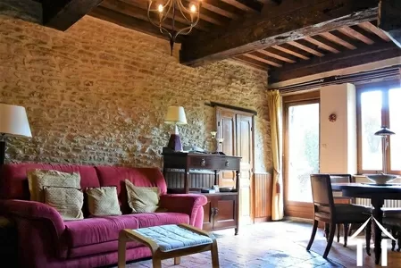 living room with exposed stone and beams