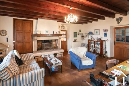 Séjour-salle à manger avec cheminée. A droite, la porte de la cuisineSéjour-salle à manger avec cheminée. A droite, la porte de la cuisine