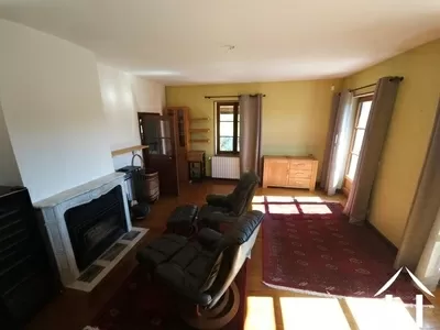 Woonkamer met open haard en toegang tot het balkon terras