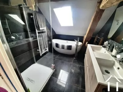 Badkamer met bad, douche en dubbele wastafels